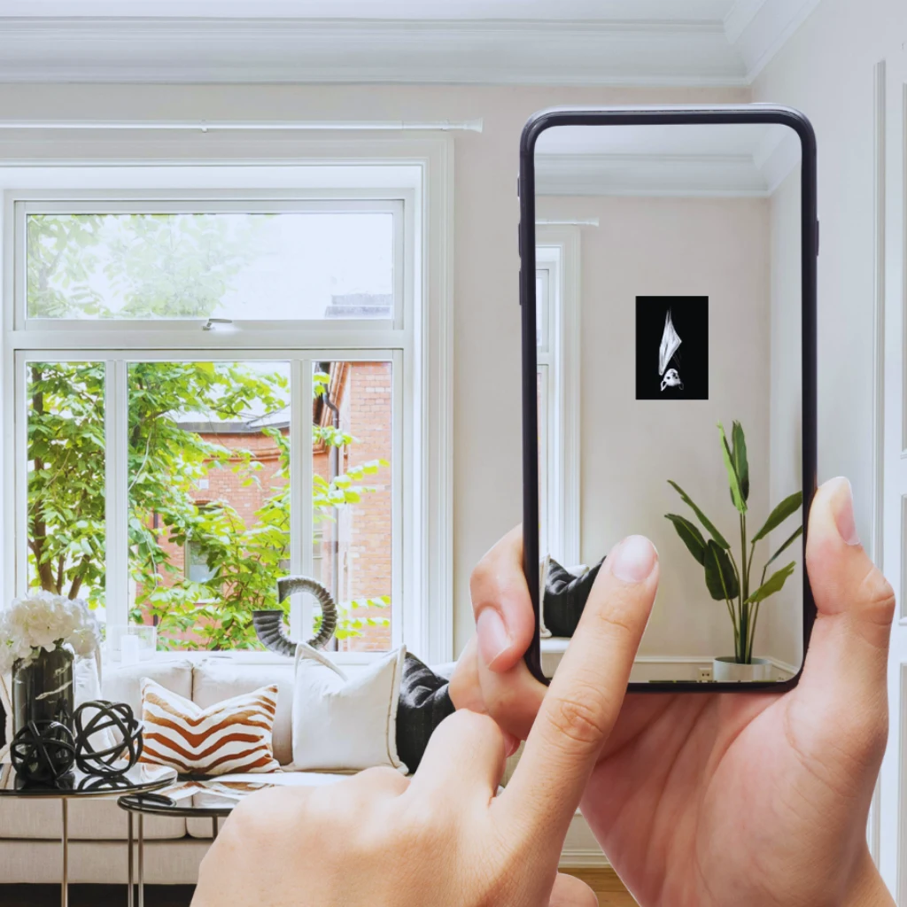 Phone held up in a living room using the AR viewer to preview a Nightlife painting on the wall before buying